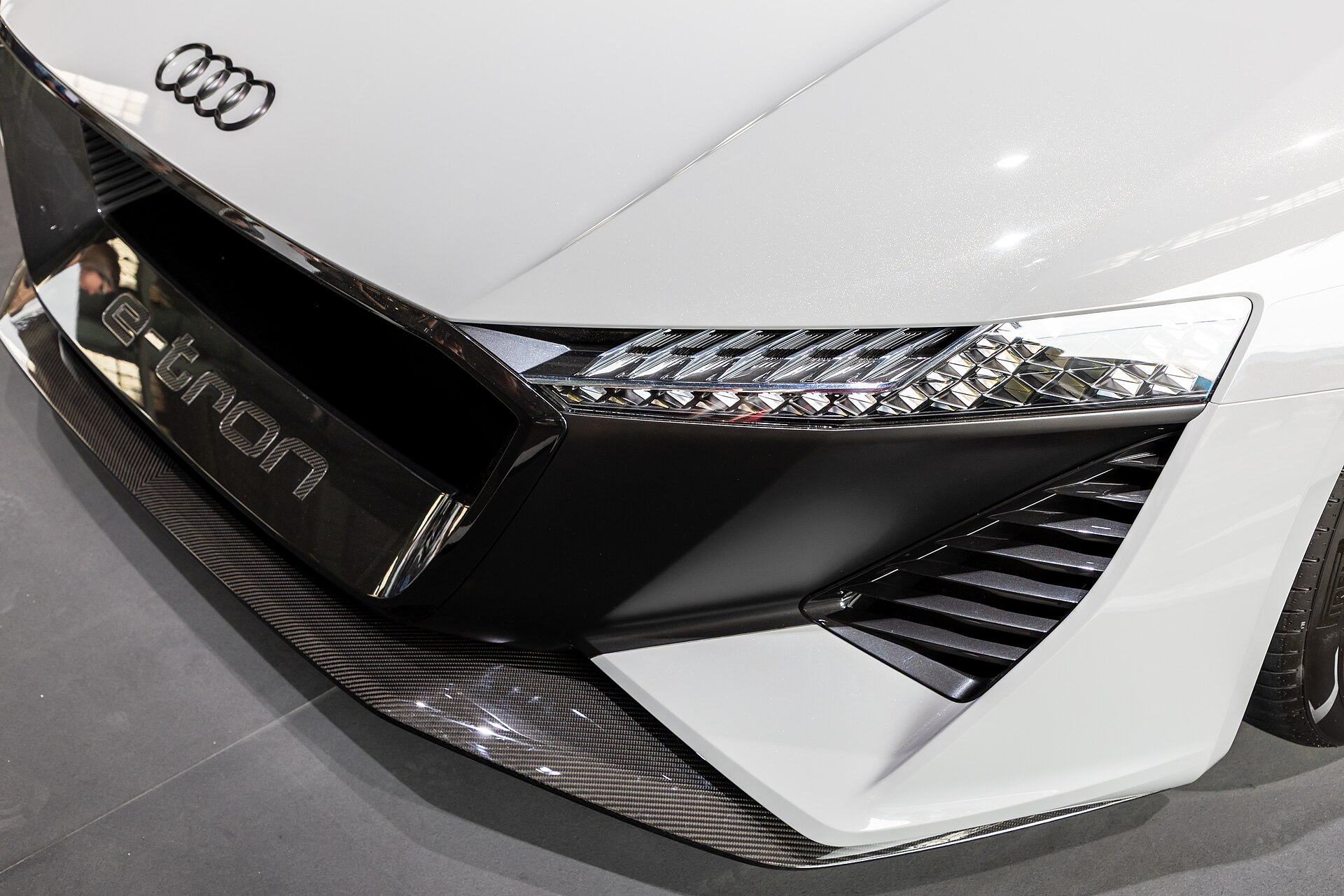 A white Audi e-tron GT displays its front design, highlighting innovative electric vehicle technology.